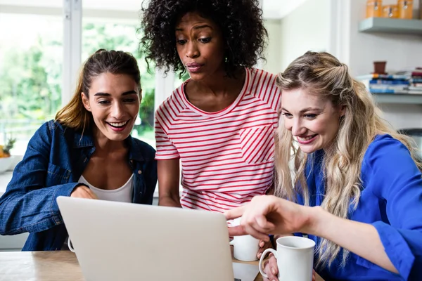 Freunde lächeln beim Blick in Laptop — Stockfoto