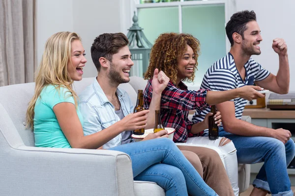 Fröhliche multiethnische Freunde genießen Fußballspiel zu Hause — Stockfoto