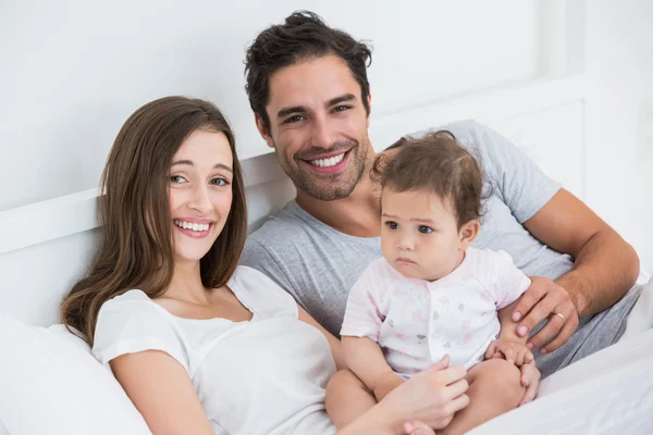 Met babymeisje rusten op bed (echt) paar — Stockfoto