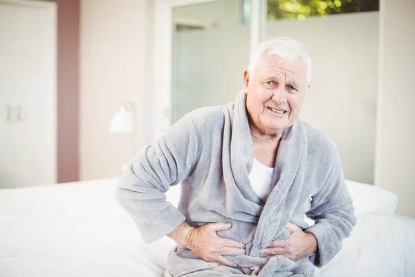 Senior man fronsen met buikpijn — Stockfoto