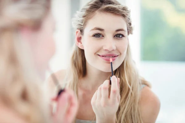 Frau trägt Lipgloss auf — Stockfoto