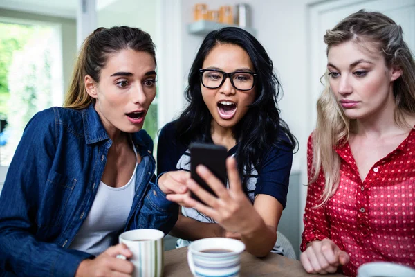 Amigos sorprendidos mientras miraba en el teléfono — Foto de Stock