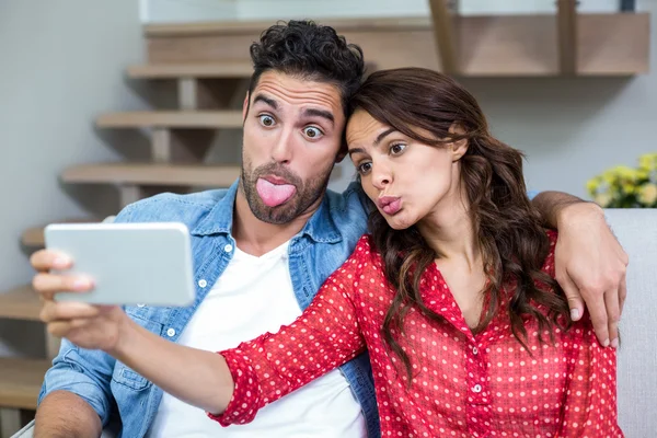 Casal fazendo caras enquanto toma selfie — Fotografia de Stock
