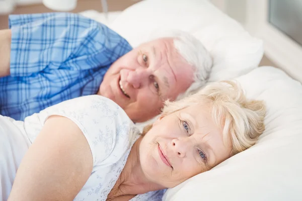 Porträtt av happy senior par vilandes på sängen — Stockfoto