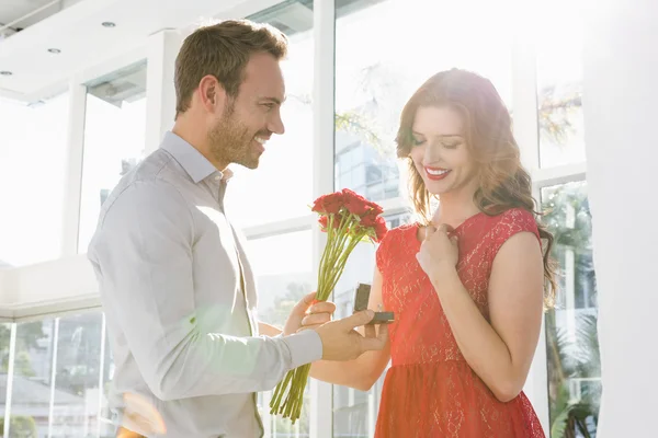Hombre ofreciendo flores y anillo de compromiso — Foto de Stock