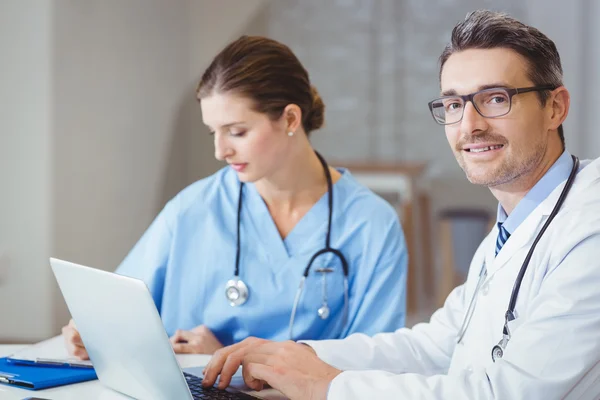 Arzt sitzt am Schreibtisch — Stockfoto