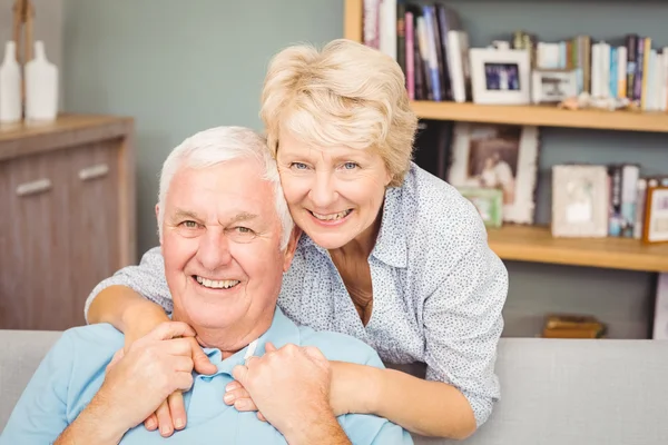 Senior couple against bookshelf — Stock Photo, Image