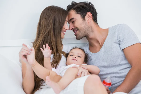 Pareja disfrutando con el bebé en la cama — Foto de Stock