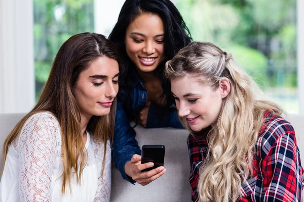 Amigas buscando en el teléfono móvil — Foto de Stock