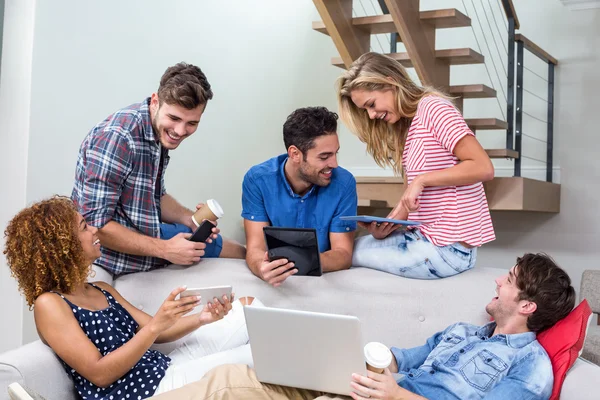 Friends using modern technologies on sofa — Stock Photo, Image