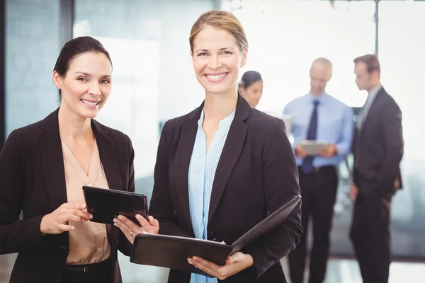 Femmes d'affaires tenant tablette numérique et fichier — Photo