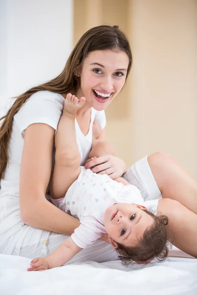 Mother holding baby on bed — Stock Photo, Image