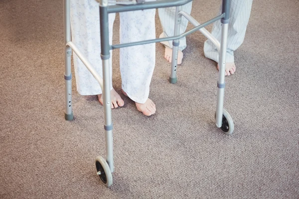 Elderly man and woman with walker — Stock Photo, Image