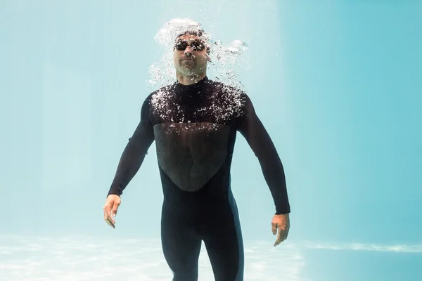 Hombre con traje de neopreno y de pie bajo el agua —  Fotos de Stock