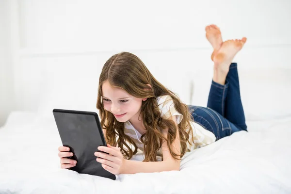 Flickan med digital tablet på sängen — Stockfoto