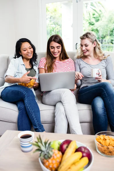 Amici di sesso femminile in cerca di laptop a casa — Foto Stock