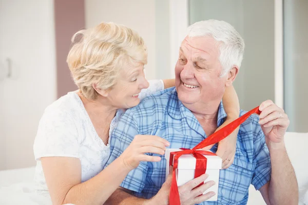 Lyckliga senior paret öppning present — Stockfoto