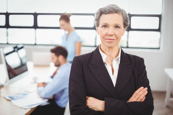 Businesswoman with colleague working in background — Stock Photo, Image
