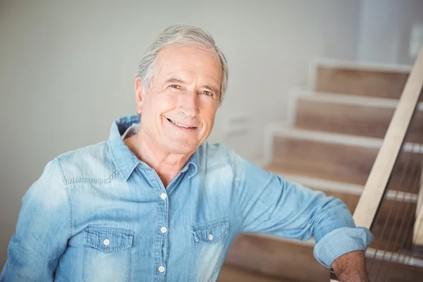 Retrato de hombre mayor sonriente contra escalera — Foto de Stock