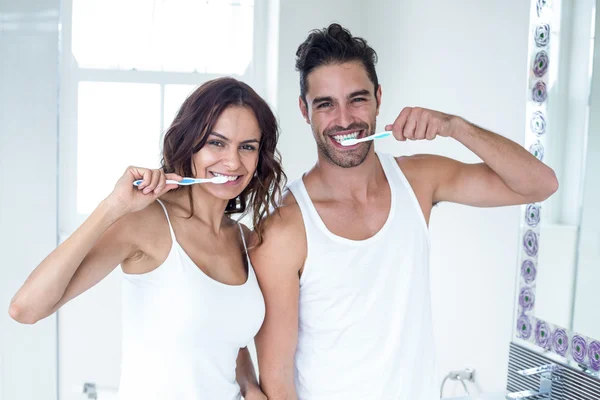 Pareja cepillarse los dientes en el baño — Foto de Stock