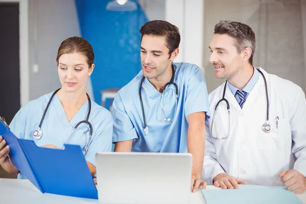 Male doctor and colleagues with clipboard — Stock Photo, Image