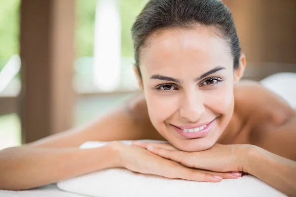 Frau lächelt, während sie auf Massagetisch ruht — Stockfoto