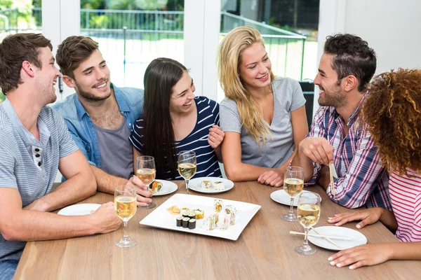 Vänner njuta av sushi och vin — Stockfoto