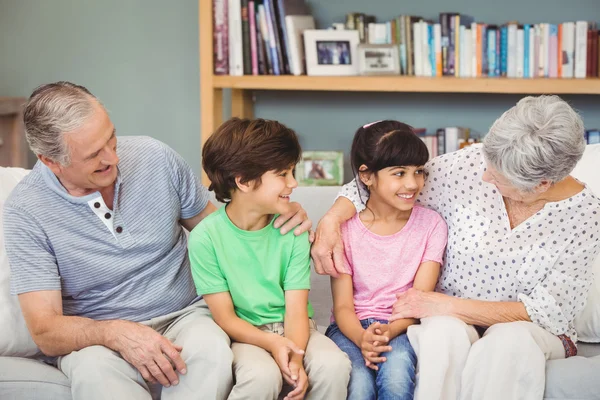 Grandchildren with grandparents on sofa — Stock Photo, Image