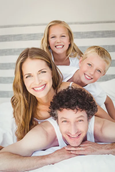Famille souriante sur le lit à la maison — Photo