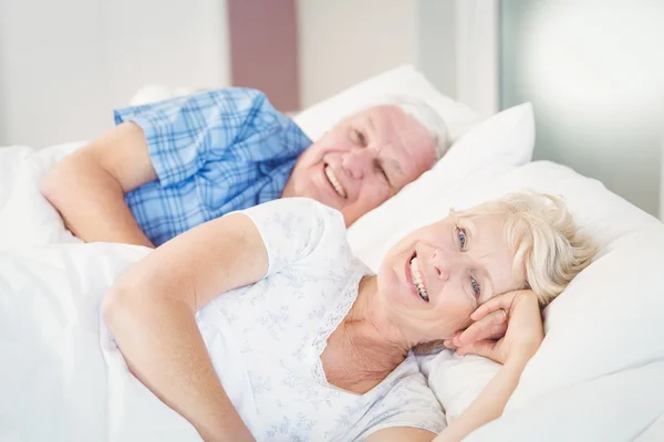 Seniorin ruht neben Mann auf Bett — Stockfoto