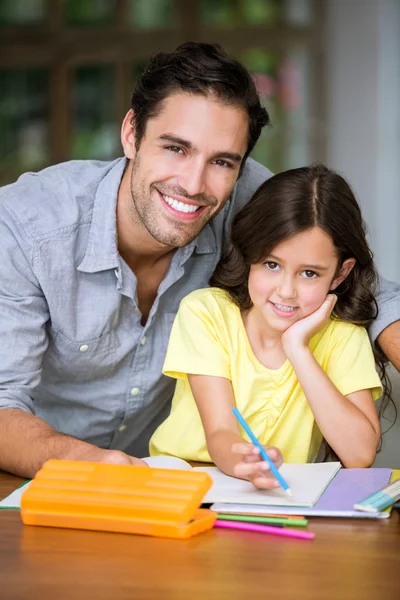 Portrait of smiling father and daughter studying Royalty Free Stock Photos