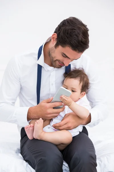 Pai segurando telefone celular com bebê — Fotografia de Stock