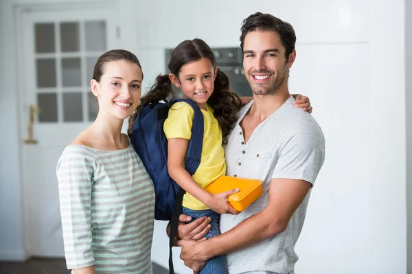 Familia con hija sosteniendo lonchera —  Fotos de Stock