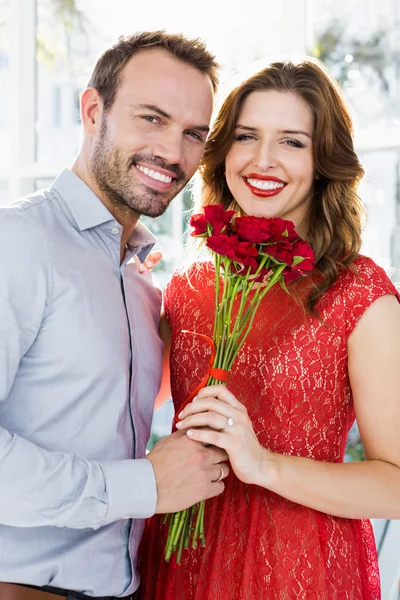 Mann bietet Frau Blumenstrauß an — Stockfoto