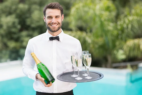 Ober holding champagne flutes en fles — Stockfoto