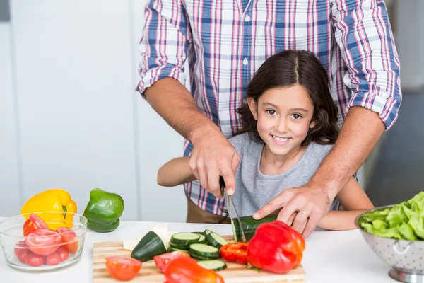 Filha cortando legumes com o pai — Fotografia de Stock