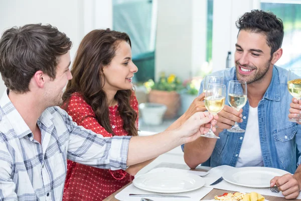 Amigos felices brindando por el vino blanco — Foto de Stock