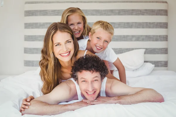ベッドの上の幸せな家族の笑顔 — ストック写真