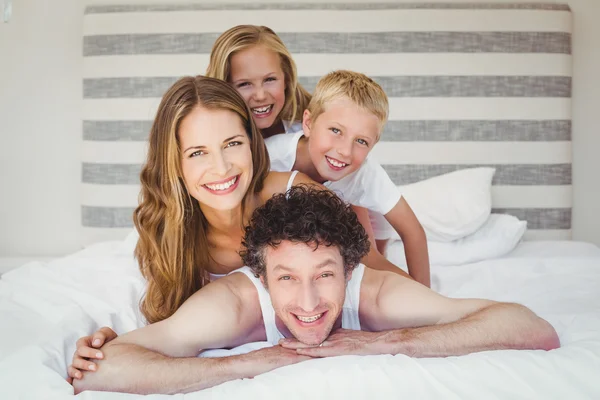 Lächelnde glückliche Familie im Bett — Stockfoto