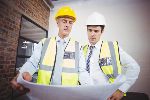 Arquitectos trabajando mientras sostienen el plano —  Fotos de Stock