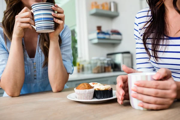 Amigos femininos segurando canecas de café — Fotografia de Stock