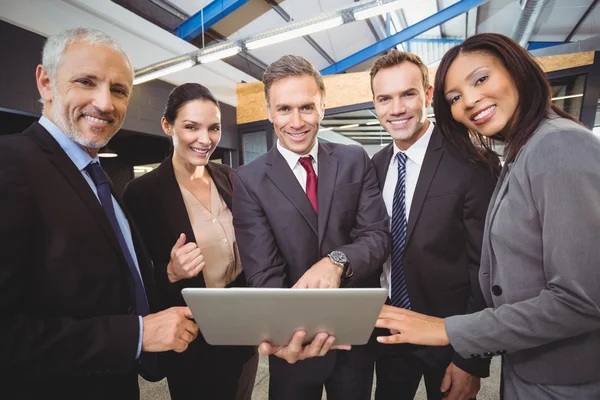 Empresários em pé junto com laptop — Fotografia de Stock