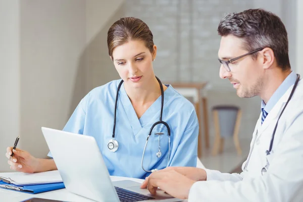 Doctor with colleague working on laptop — Stock Photo, Image