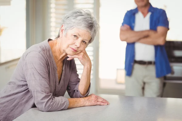 Bezorgd senior vrouw met een man die in de achtergrond — Stockfoto