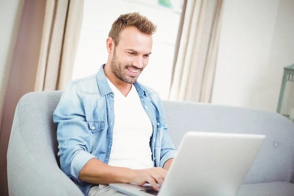 Jovem usando laptop em casa — Fotografia de Stock