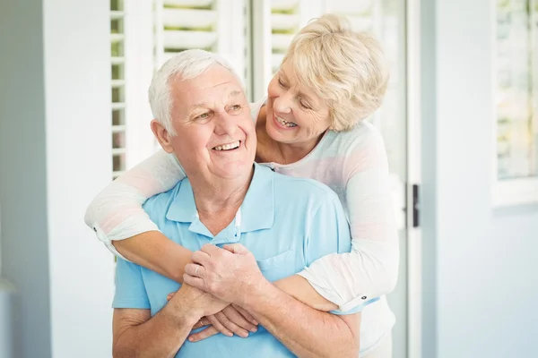 Couple smiling while hugging at home — Stock Photo, Image