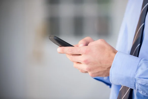 Uomo d'affari che utilizza il telefono cellulare — Foto Stock