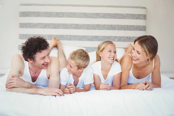 Familia relajándose en la cama — Foto de Stock