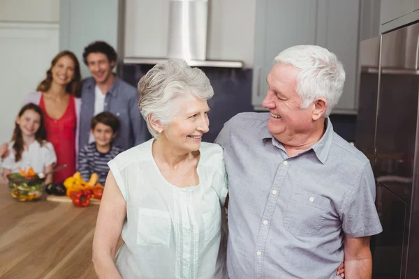 Grootouders met familie in keuken — Stockfoto