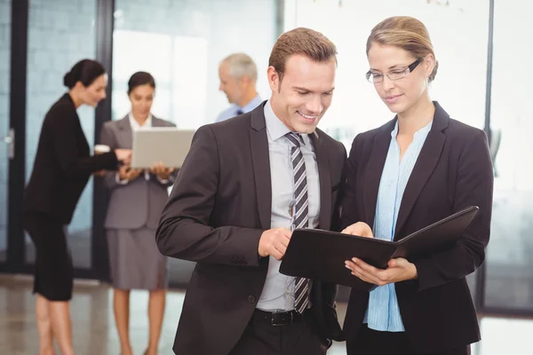 Empresario y mujer de negocios mirando el archivo — Foto de Stock